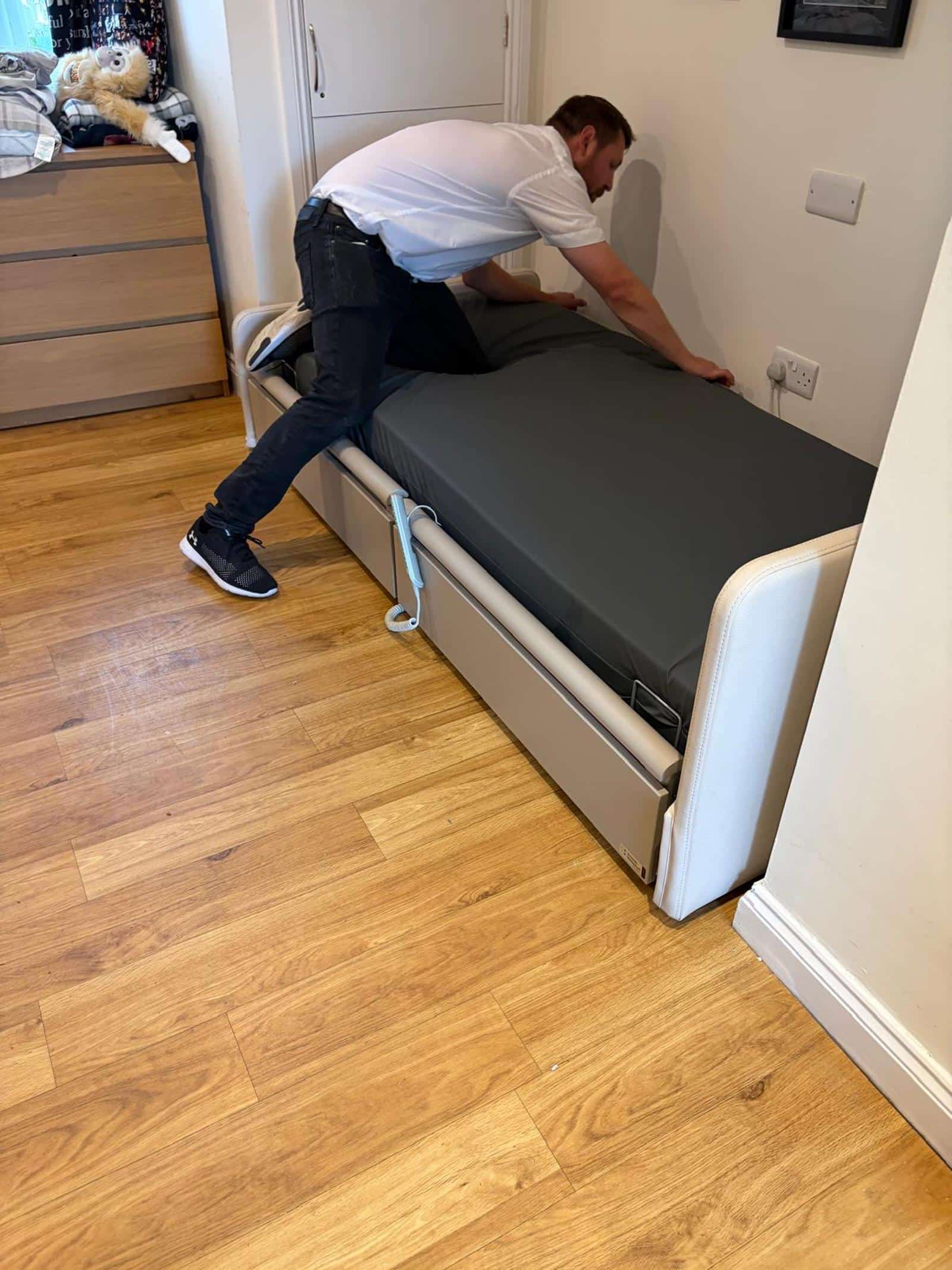 E&M engineer repairing and adjusting a profiling bed in a home